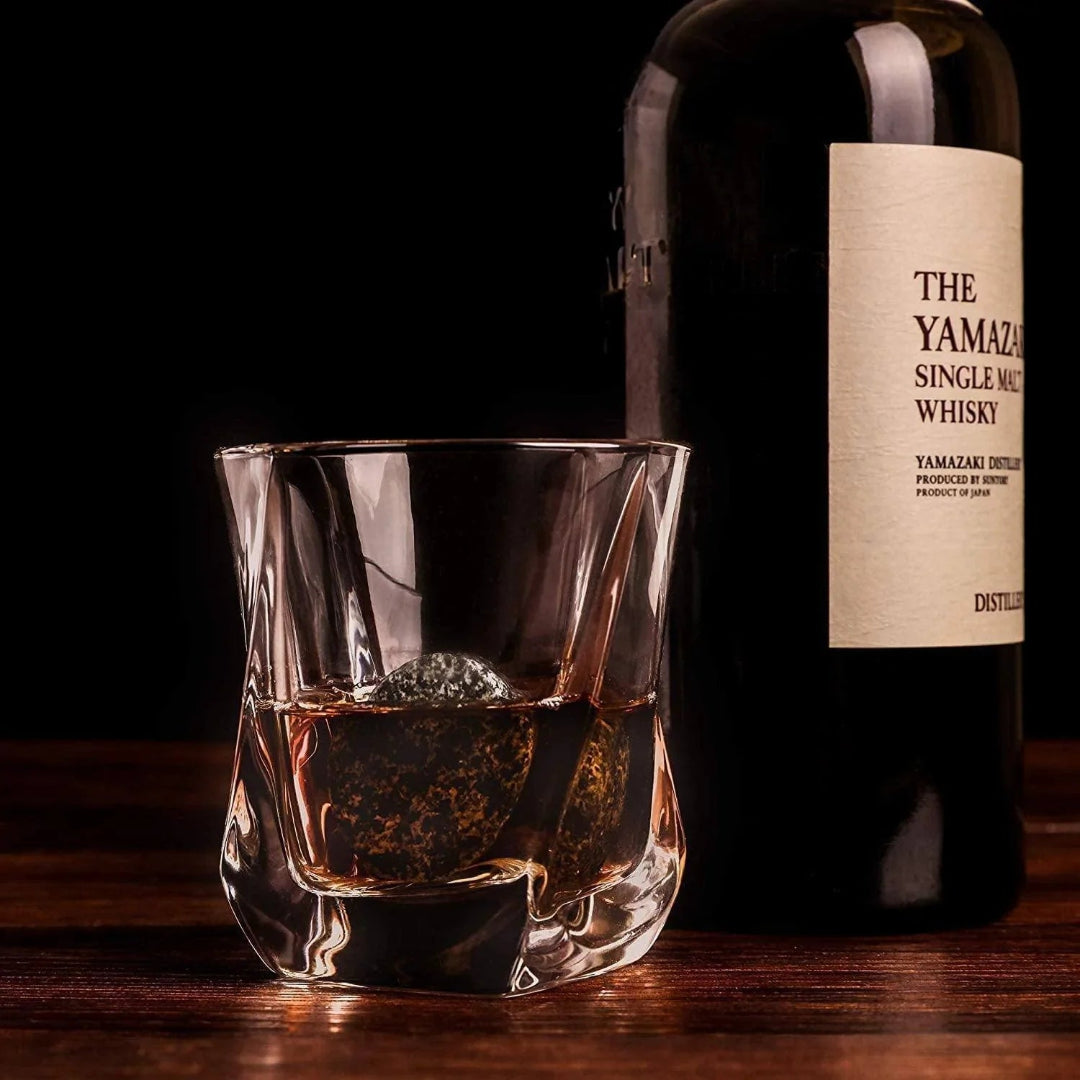 Yamazaki whisky bottle with a glass of whisky on a wooden surface