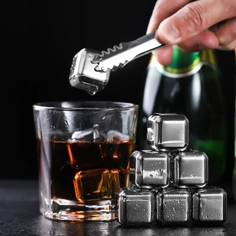 Metallic ice cubes with a glass of whiskey and a bottle in the background.