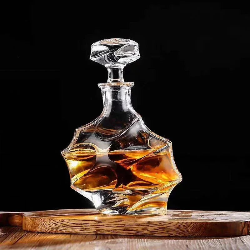 Glass whiskey decanter with a geometric design on a wooden coaster against a black background