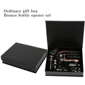 Bronze bottle opener set in an open black gift box on a white background