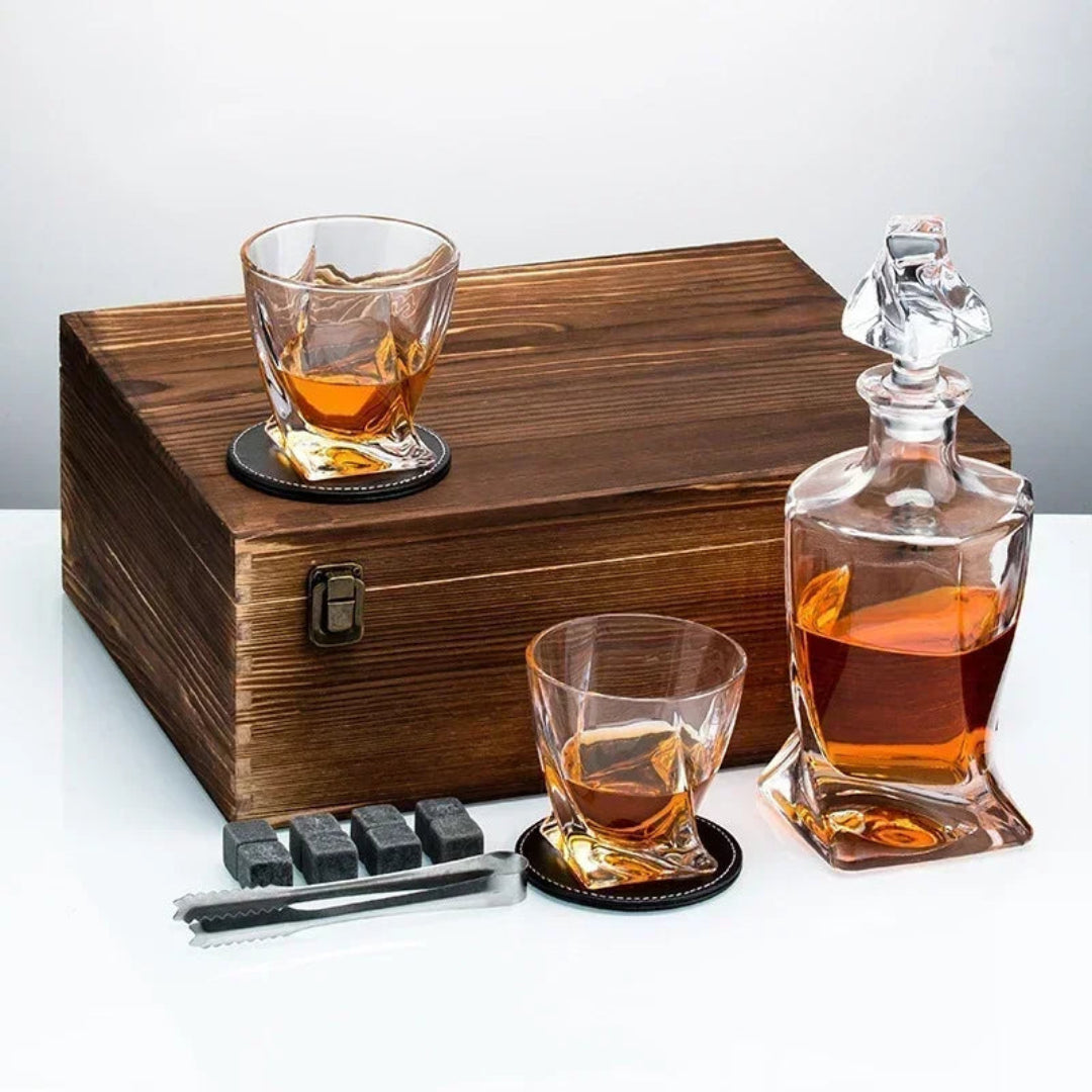 Whiskey decanter set with glasses and coasters on a wooden box.