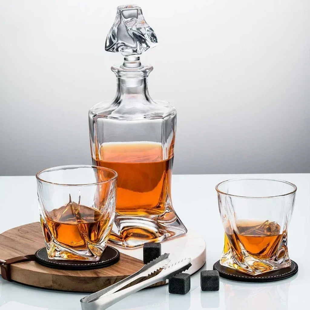 Whiskey decanter with two glasses on a wooden coaster set against a gray background